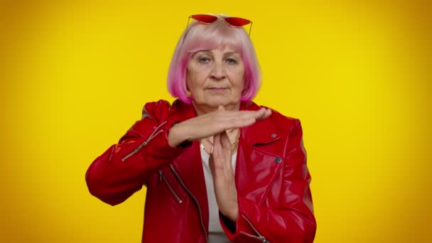 Senior viejo estilo rockero abuela mujer con el pelo rosa mostrando el gesto de tiempo de espera, límite o señal de parada — Vídeos de Stock