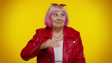 Olgun, gri saçlı bir büyükanne. Gözlerinin üstünde el ele tutuşmuş. Uzağa bakıyor, birini arıyor.