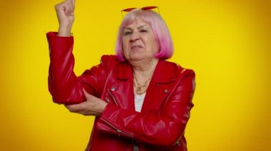 Yaşlı yaşlı kadın pazılarını gösteriyor, kendine güvenen, haklar için savaşacak gücü hisseden.