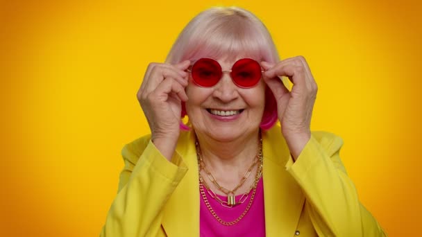 Felice giocoso elegante anziana donna in occhiali da sole lampeggiante occhio, guardando la fotocamera con sorriso — Video Stock