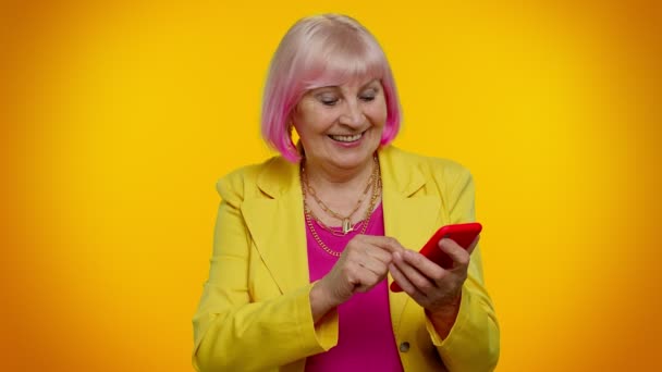 Starsza babcia używa telefonu komórkowego wpisując nowy post, SMS, przeglądanie, portale społecznościowe — Wideo stockowe