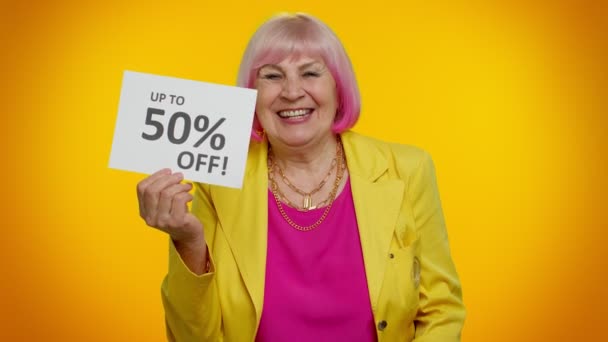 Femme mamie senior montrant des sacs à provisions et jusqu'à 50 pour cent hors inscriptions bannière, Black Friday — Video