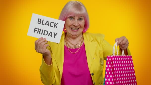 Ηλικιωμένη γιαγιά γυναίκα δείχνει Black Friday επιγραφή banner κείμενο, διαφημίσεις εκπτώσεις, χαμηλές τιμές — Αρχείο Βίντεο