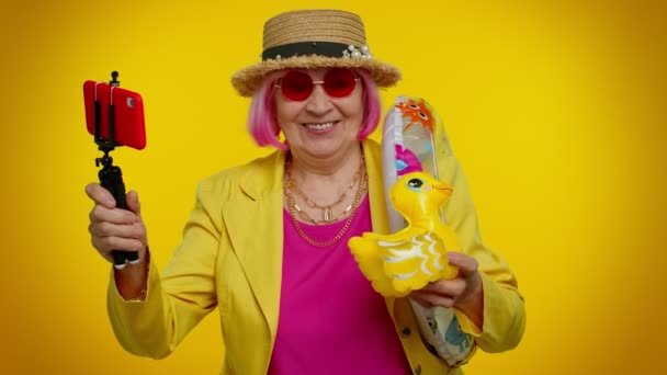 Зрелая бабушка путешественник блоггер в солнечных очках, делает селфи на мобильный телефон, видео-звонок онлайн — стоковое видео