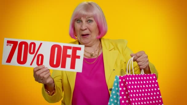 Senior oma vrouw tonen boodschappentassen en tot 70 Procent Off inscripties banner, Black Friday — Stockvideo