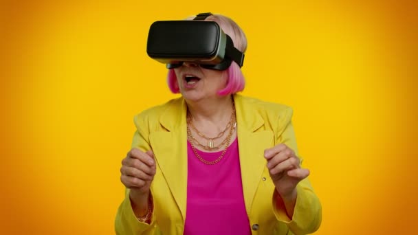 老年妇女使用虚拟现实VR应用程序头盔玩模拟三维电子游戏绘图 — 图库视频影像