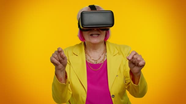 年长的老太婆用耳机头盔应用玩模拟虚拟现实VR游戏 — 图库视频影像