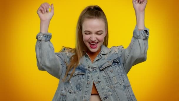 Chica adolescente en chaqueta de mezclilla gritando, levantando los puños en gesto lo hice, celebrando el éxito, ganando — Vídeos de Stock