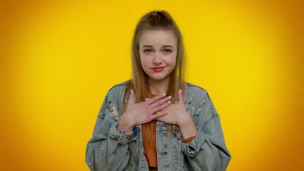 Dívka na žlutém pozadí studia ukazující prstem se mě ptá, komu děkuji, že to nepotřebuji. — Stock video