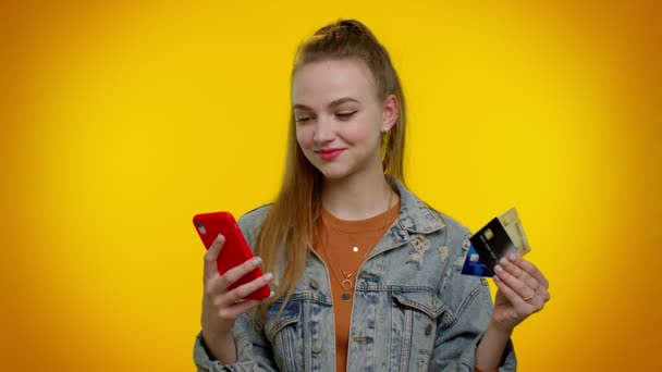 Chica adolescente usando tarjetas bancarias de crédito y teléfono inteligente durante la transferencia de dinero, compras en línea — Vídeos de Stock