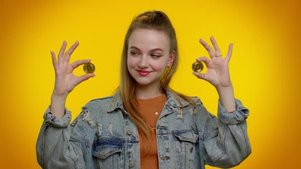 Docela bohaté stylové teen dívka oklamání, ukazuje zlaté bitcoiny, kryptoměna investice, těžba — Stock video