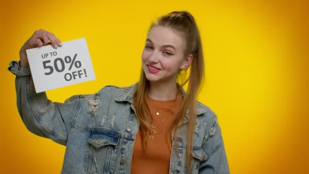 Menina adolescente alegre mostrando sacos de compras e até 50% Off banner inscrições, Black Friday — Vídeo de Stock