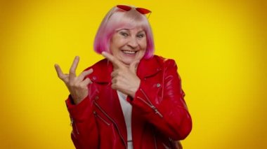 Olgun yaşlı büyükanne, şakacı, aptal surat ifadeleri takınıyor, yüzünü buruşturuyor, dil gösteriyor.