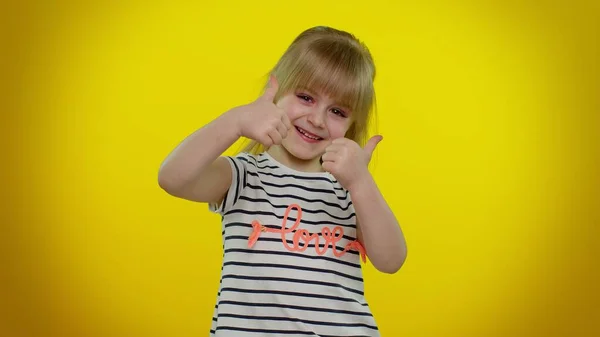 Ung barn flicka höjer tummen upp håller med eller ger positivt svar rekommenderar reklam gillar bra — Stockfoto