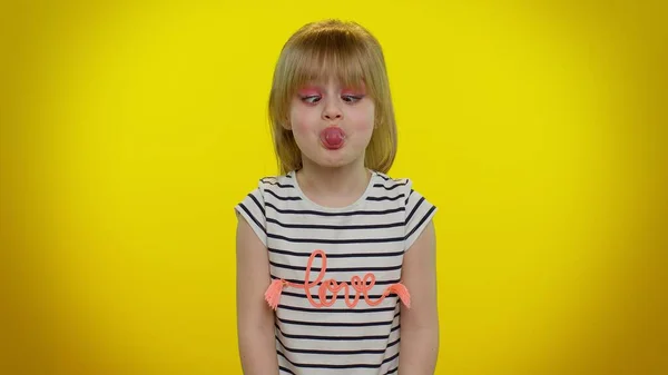 Смешная девочка-ребенок делает игривые глупые выражения лица и гримасы, дурачит, показывает язык — стоковое фото
