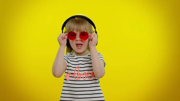 Divertente giocoso bambino biondo ragazza ascoltando musica tramite cuffie, ballare discoteca ingannare divertirsi — Foto Stock