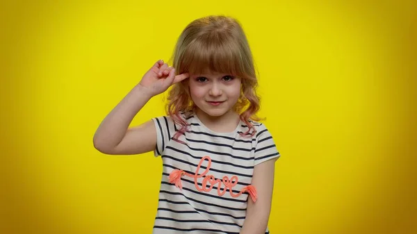 Ragazzina bambina che indica la macchina fotografica e mostra stupido gesto, incolpando qualche idiota per piano folle — Foto Stock