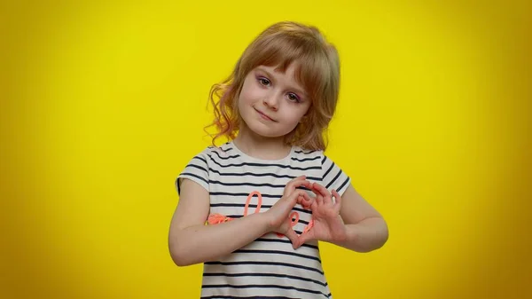 Lachend kind meisje maakt hart gebaar toont liefde teken drukt goede gevoelens en sympathie — Stockfoto