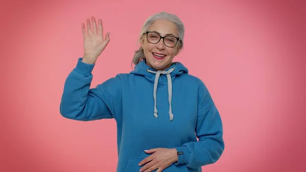 Heureuse femme âgée amicale agite la paume des mains dans le geste bonjour accueille quelqu'un émotions positives — Photo