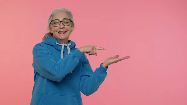 Madura abuela mostrando pulgares hacia arriba y apuntando lugar vacío, área de publicidad para texto comercial — Foto de Stock