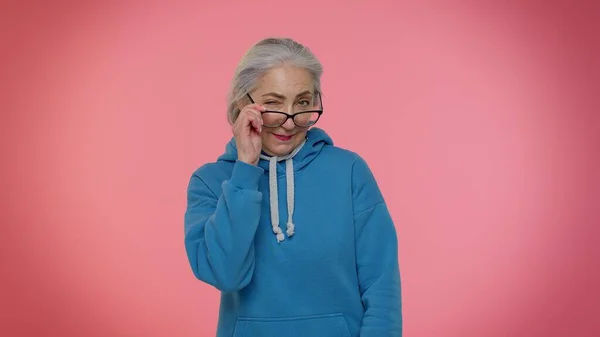 Juguetón feliz anciana abuela mujer parpadeando ojo, mirando a la cámara con sonrisa, expresando optimismo — Foto de Stock