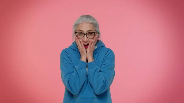 Excité étonné femme âgée levant la main dans la surprise en regardant la caméra, choqué par la victoire soudaine — Photo