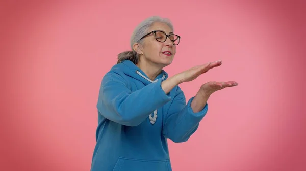 Dojrzałe stary babcia kobieta pokazując marnowanie lub rzucanie pieniędzy wokół strony gest, więcej wskazówek, duży zysk — Zdjęcie stockowe