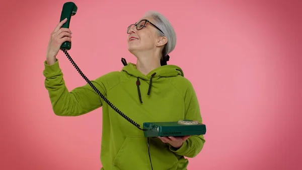 Loca anciana abuela anciana hablando en el teléfono de la vendimia por cable de los años 80, engañando haciendo caras tontas —  Fotos de Stock