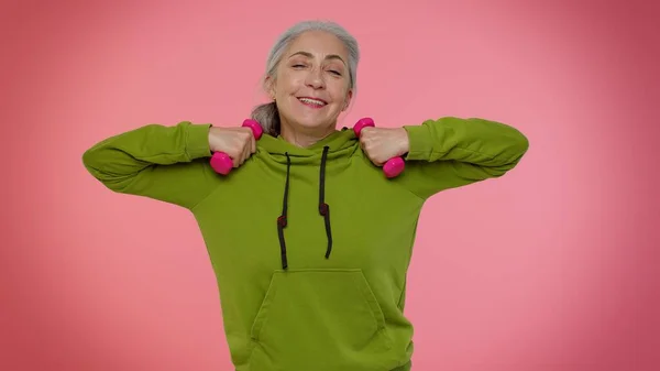 年长的老太太运动健美，提起粉色哑铃，练习普拉提，保健 — 图库照片