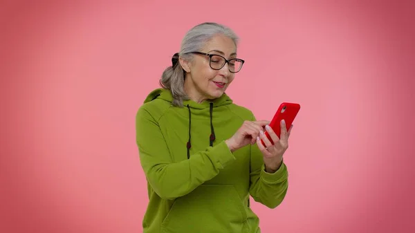 Senior old granny woman using mobile phone typing new post, sms message, browsing, social networks — Stock Photo, Image