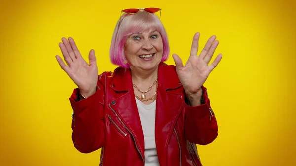 Feliz amigable anciana olas palma de la mano en gesto de saludo da la bienvenida a alguien emociones positivas — Foto de Stock