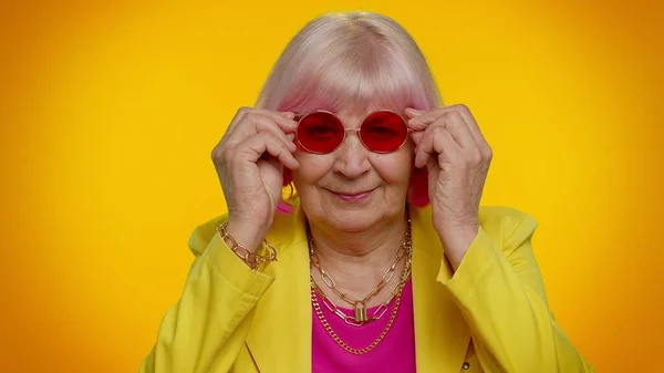 Retrato de anciana anciana seductora anciana elegante abuela con gafas de sol rojas, sonrisa encantadora — Foto de Stock