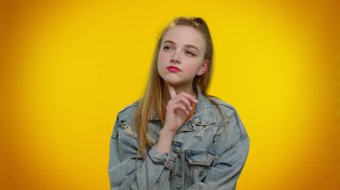 Düşünceli öğrenci kız çenesini düşünceli bir ifadeyle ovuyor, bir çözüm düşünüyor, soru soruyor.