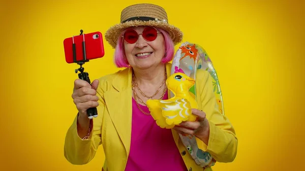 Madura abuela viajero blogger en gafas de sol, tomar selfie en el teléfono móvil, videollamada en línea — Foto de Stock