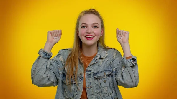Chica adolescente en chaqueta de mezclilla gritando, levantando los puños en gesto lo hice, celebrando el éxito, ganando —  Fotos de Stock