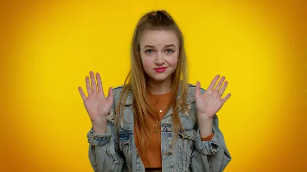 Дівчина на жовтому фоні студії, вказуючи пальці, питає себе: "Хто мені не дякую, мені це не потрібно" — стокове фото