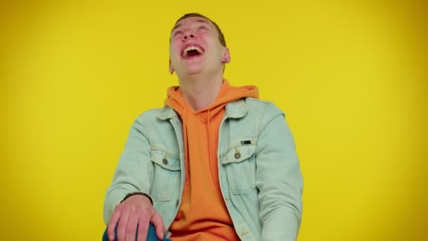 Jongeman lachen hardop na het horen van belachelijke anekdote, grappige grap, gevoel zorgeloos geamuseerd — Stockvideo