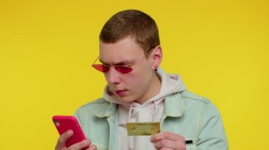 Cep telefonu ve plastik banka kartı kullanan bir adam 