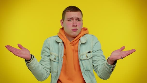 Zmatený bezradný dospívající student zvedá ruce v bezmocném gestu, zmatený obtížnou otázkou — Stock video