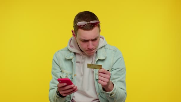 Tini férfi hitelkártyával és okostelefonnal, miközben pénzt utalnak át, vásárol online vásárlás — Stock videók