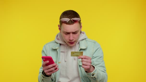 Man gebruik maken van mobiele telefoon en plastic creditcard, browsen zeggen wow ja ontdekte grote overwinning — Stockvideo