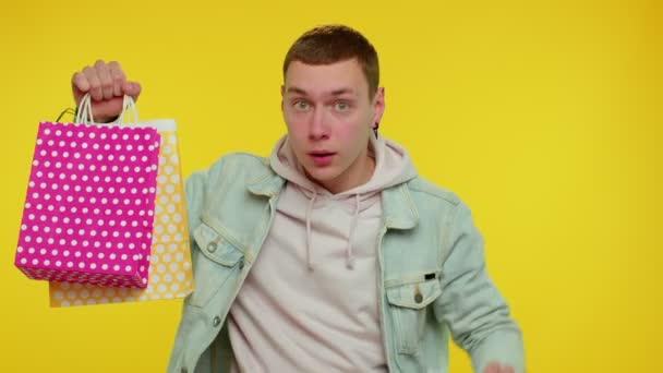 Cheerful teen man showing shopping bags and Up To 40 Percent Off inscriptions banner, Black Friday — Stock Video