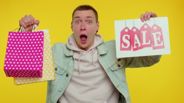 Glad student man visar Försäljning inskrift banner text, reklam rabatter låga semesterpriser — Stockvideo