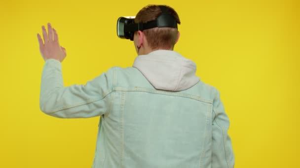 Hombre usando la tecnología futurista de realidad virtual casco de auriculares VR para jugar simulación videojuego 3D — Vídeo de stock