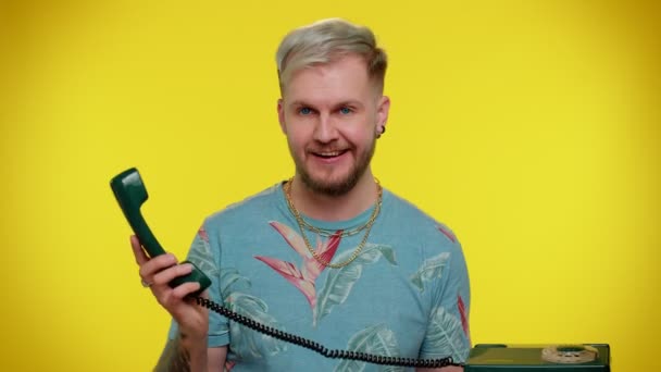 Crazy sincere young man talking on wired vintage telephone of 80s, fooling, making silly funny faces — Stock Video