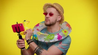 Güneş gözlüklü bir gezgin cep telefonuyla selfie çekiyor, internetten video görüşmesi yapıyor.
