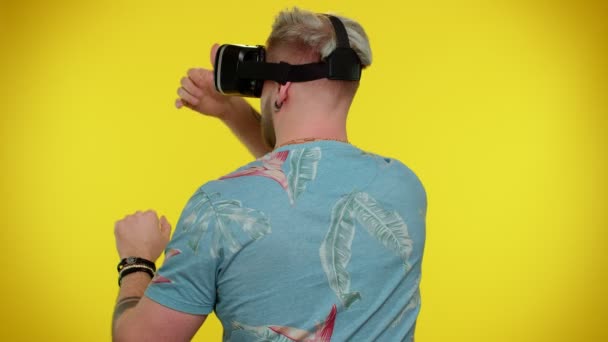 シミュレーション3Dビデオゲームをプレイするために仮想現実未来技術VRヘッドセットヘルメットを使用して男 — ストック動画