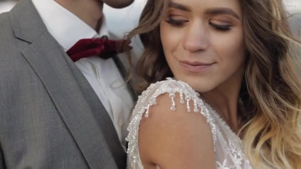 Schöne junge Braut und Bräutigam umarmen, umarmen sich am Berghang, Hochzeitspaar verliebt — Stockvideo