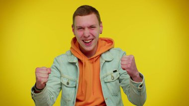 Kot ceketli genç adam bağırıyor, el kol hareketi yapıyor Başarımı kutluyorum, kazanıyorum