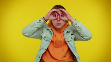 Meraklı meraklı adam elleriyle gözlerini kapatıyor ve parmaklarıyla casusluk yapıyor, saklanıyor ve dikizliyor, arıyor